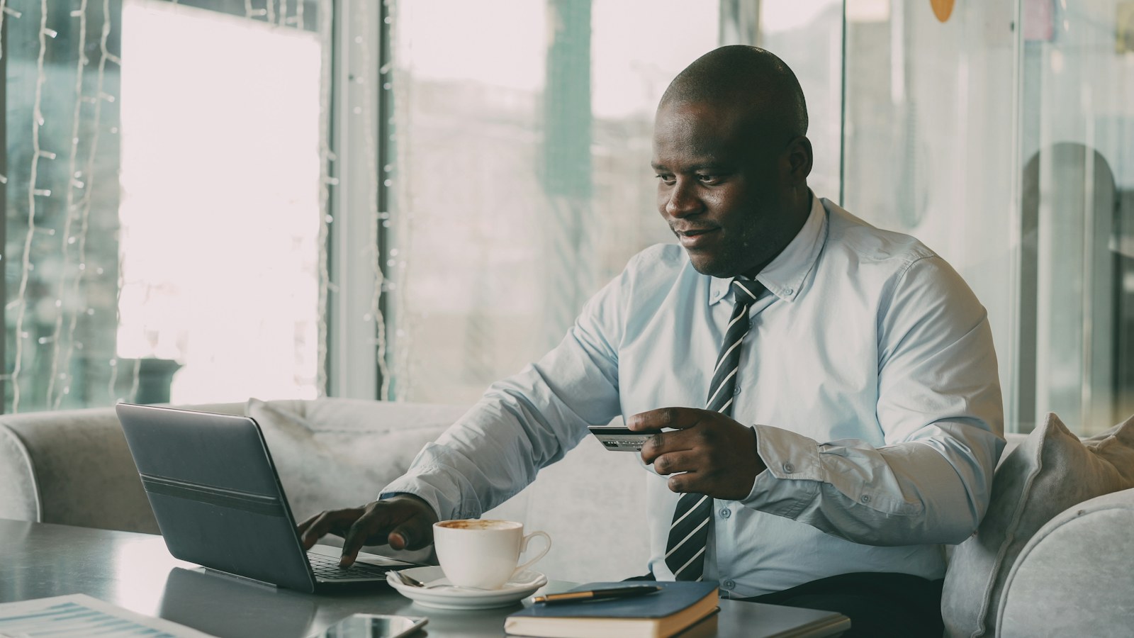 Person reviewing a card payment beside a laptop