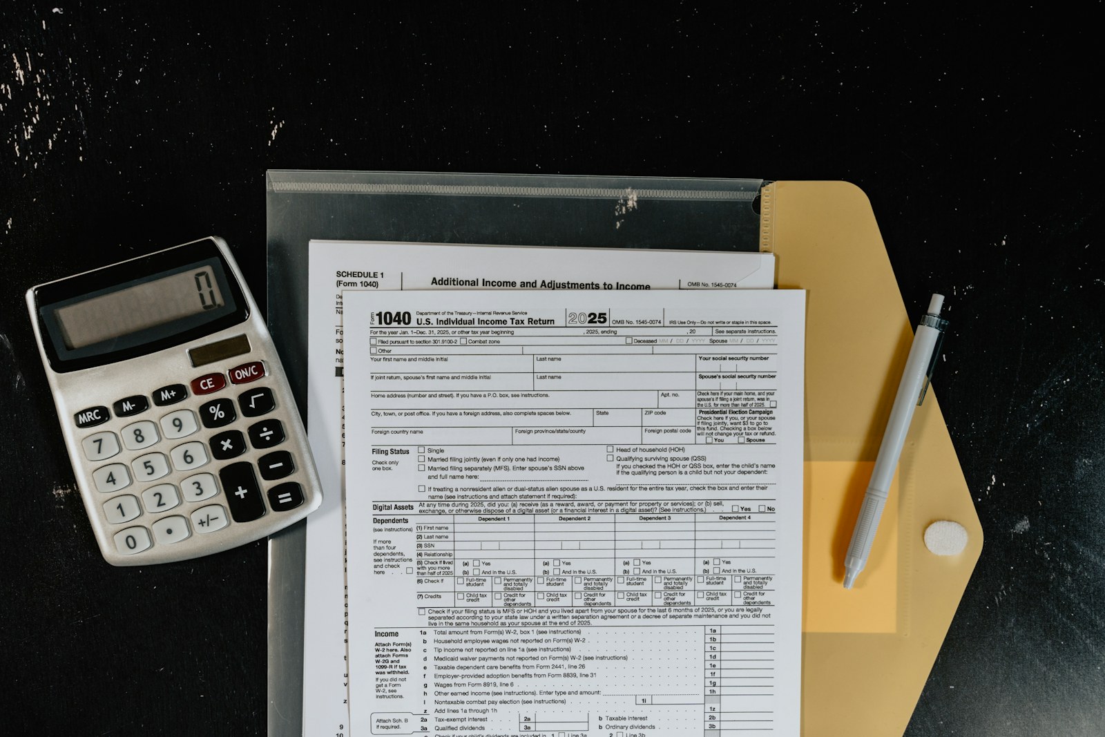 Financial forms and calculator on a dark desk